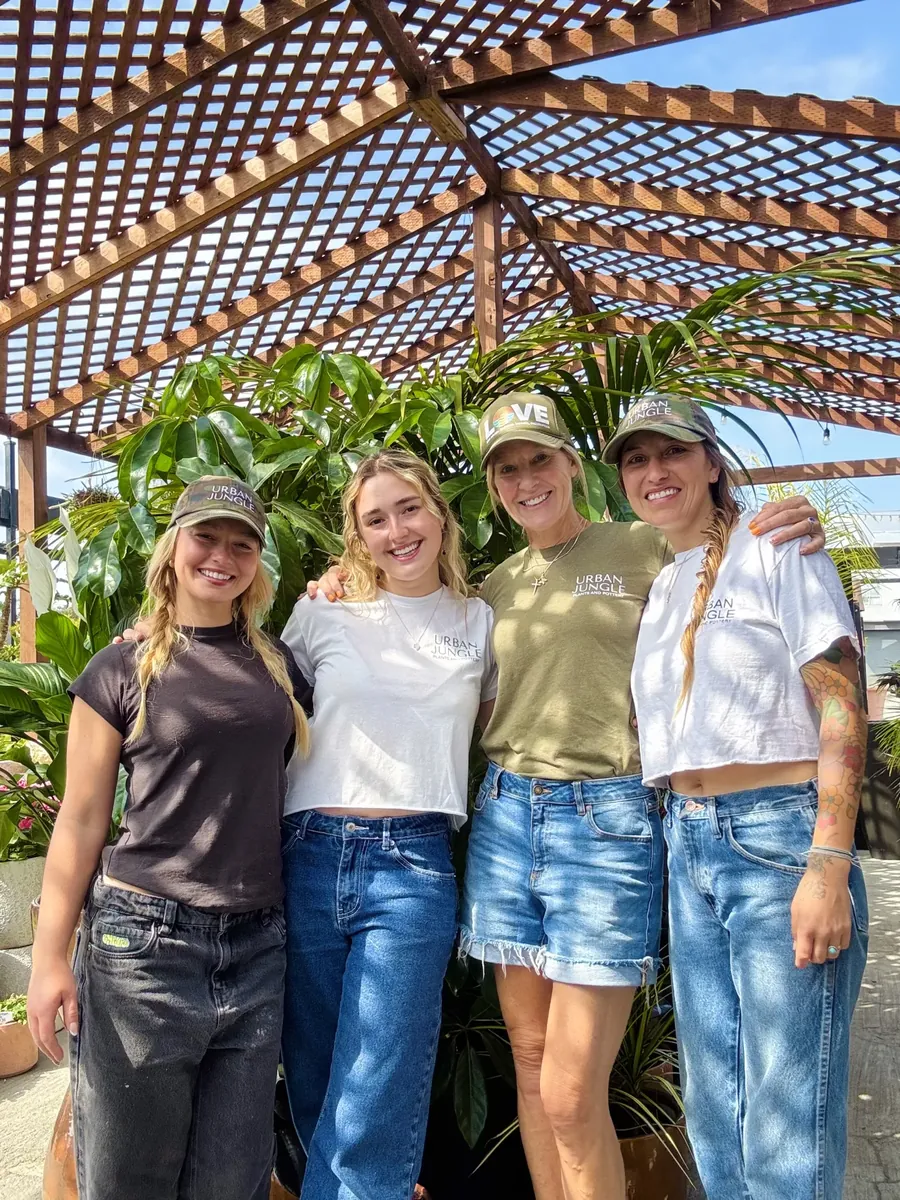 The Urban Jungle team smiling under the pergola at the shop